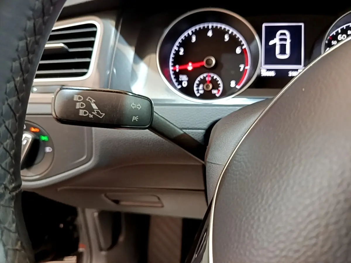 Gros plan sur le volant cuir et le combiné d'instruments de la Volkswagen Golf 1.0 TSI 115 DSG7 Connect, intérieur noir.