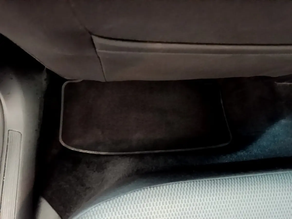 Vue rapprochée du tapis de sol noir sous le siège arrière côté gauche d’une Volkswagen Golf noire de 2019.