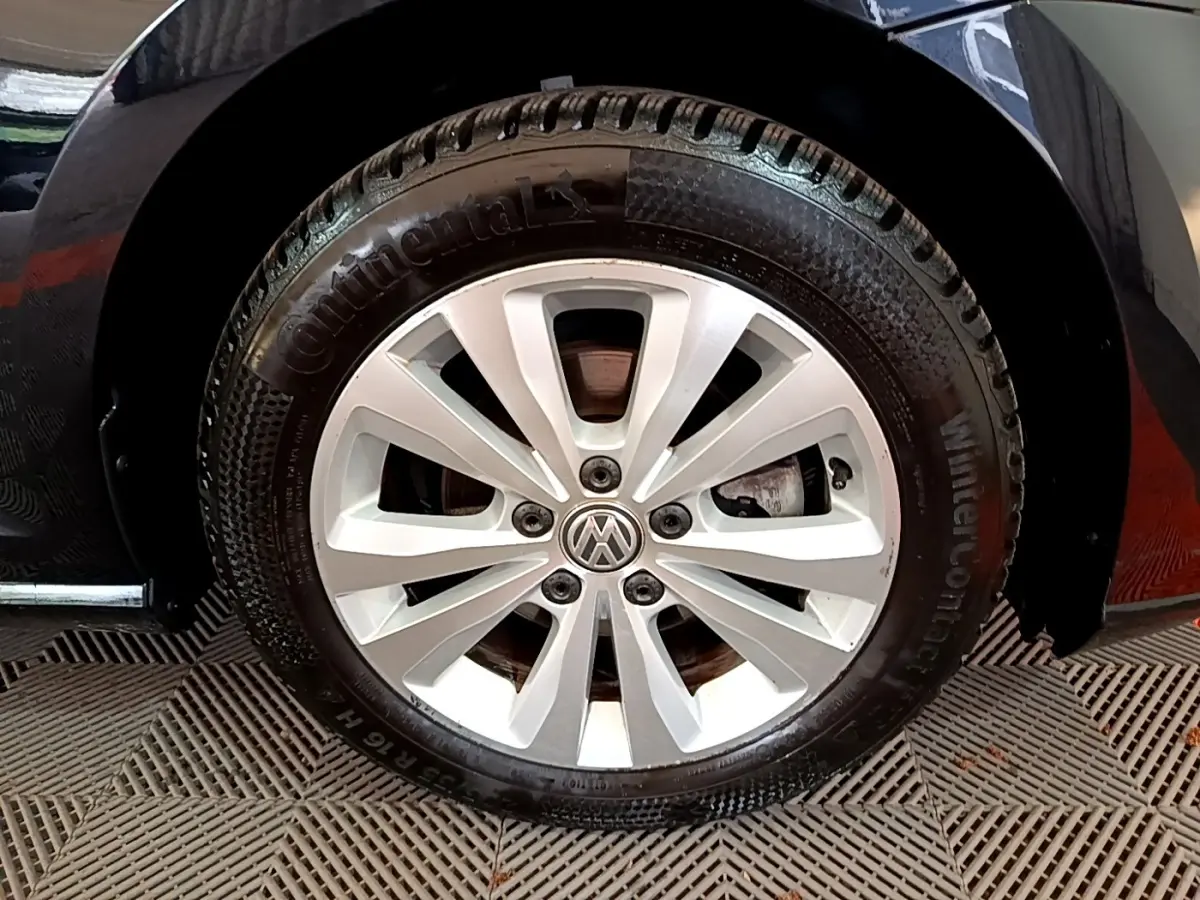 Gros plan sur la roue avant droite d’une Volkswagen Golf noire avec jante argentée et pneu Continental hiver.
