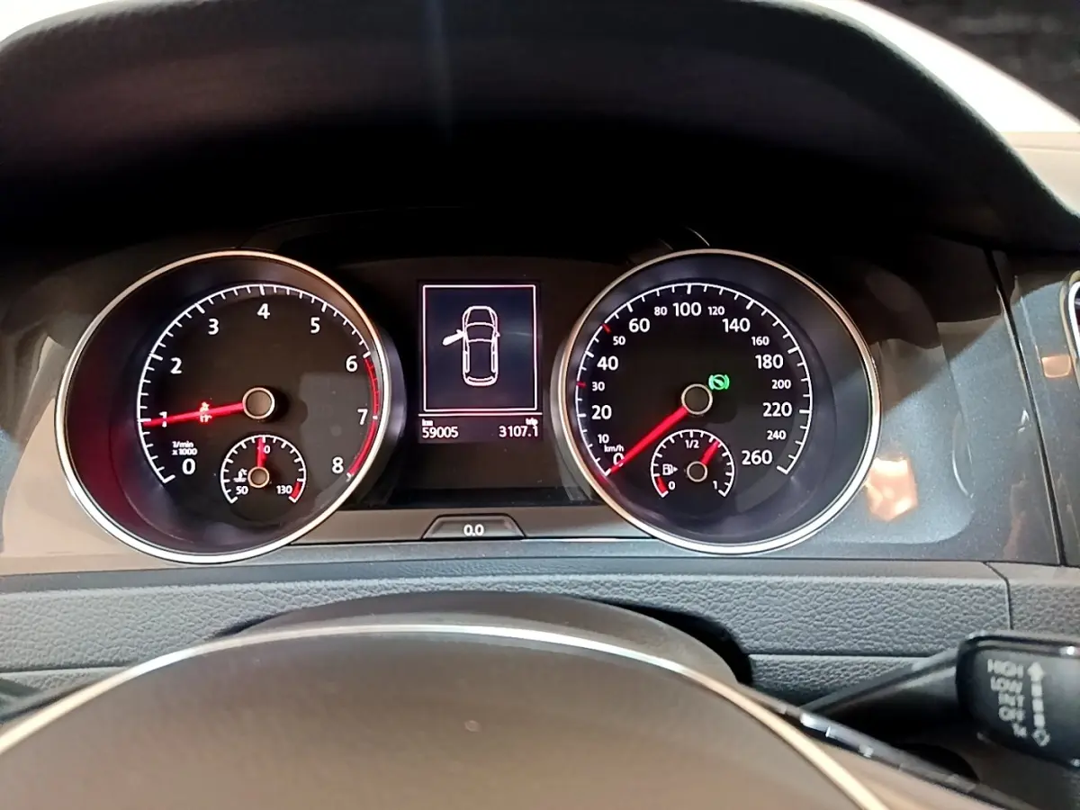 Vue rapprochée du tableau de bord de la Volkswagen Golf noire, affichant les compteurs et l'écran central numérique.