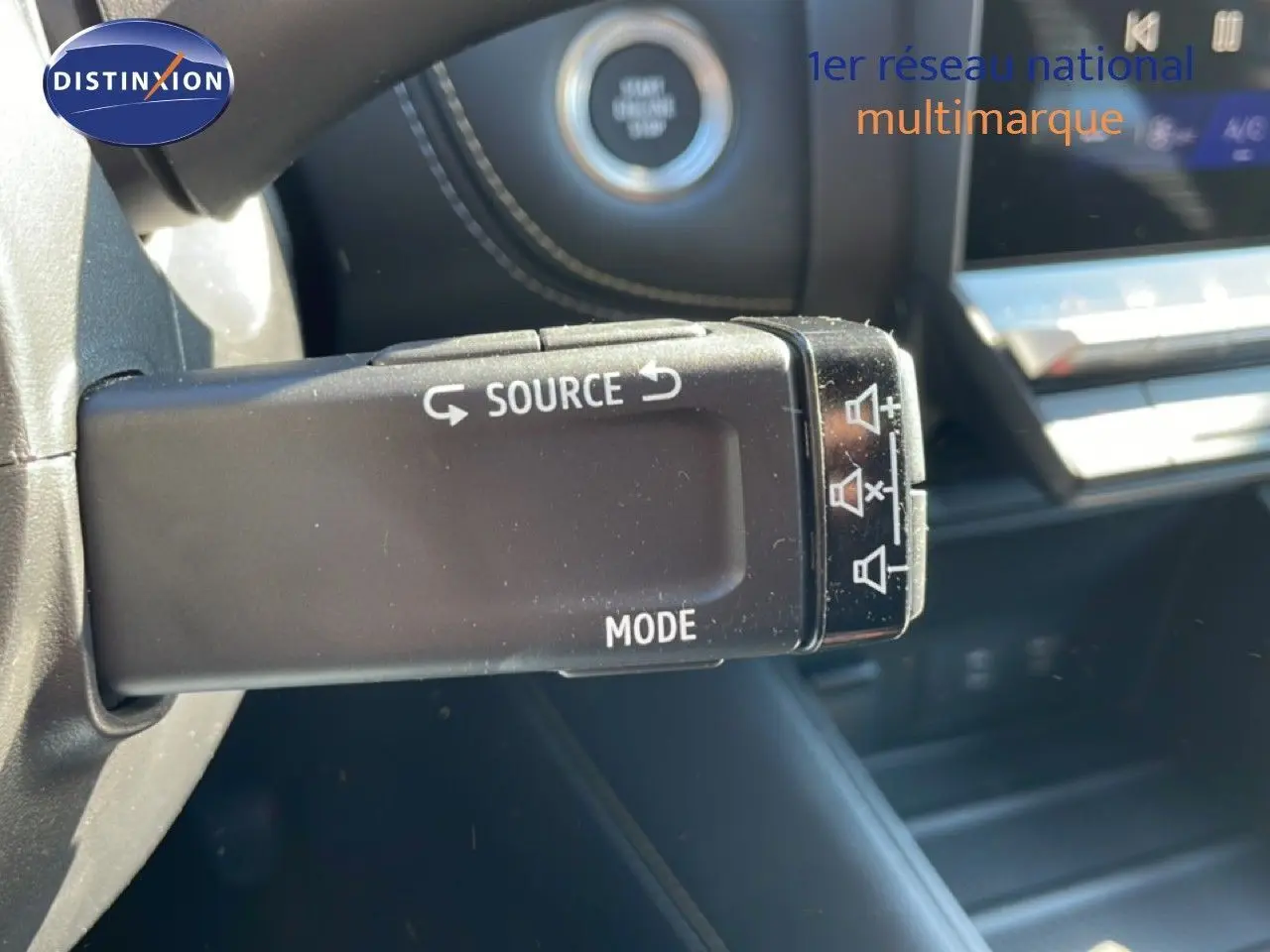 Gros plan sur la commande au volant gauche du Renault Symbioz noir étoile métal, avec tableau de bord et bouton start visible.