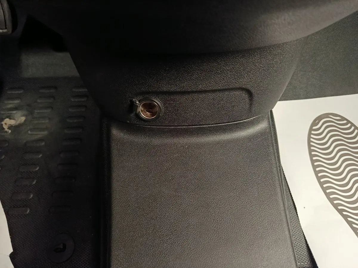 Détail de la prise 12V sur la console centrale noire du Citroën Berlingo blanc 2021, vue intérieure côté conducteur.