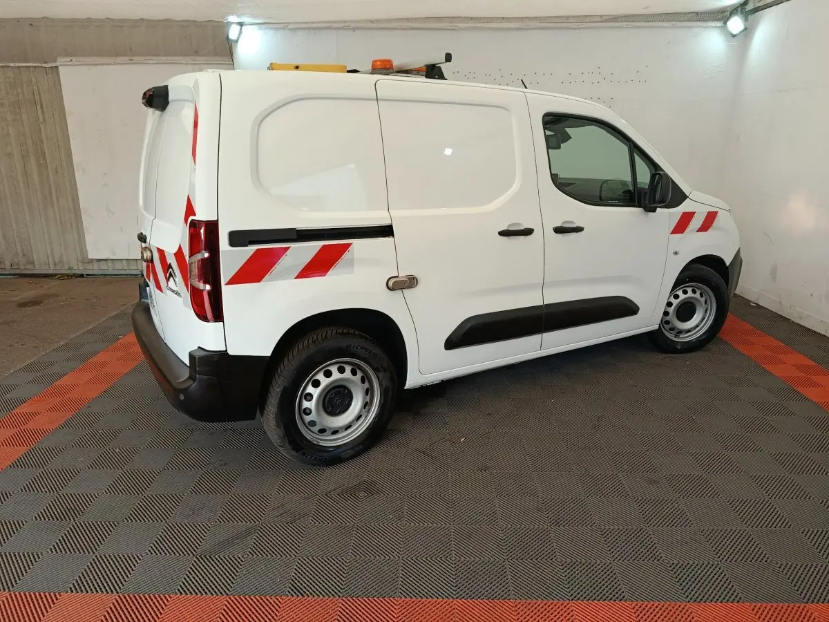 Vue de profil côté droit d’un Citroën Berlingo blanc 2021 avec bandes réfléchissantes rouges et feux arrière visibles.