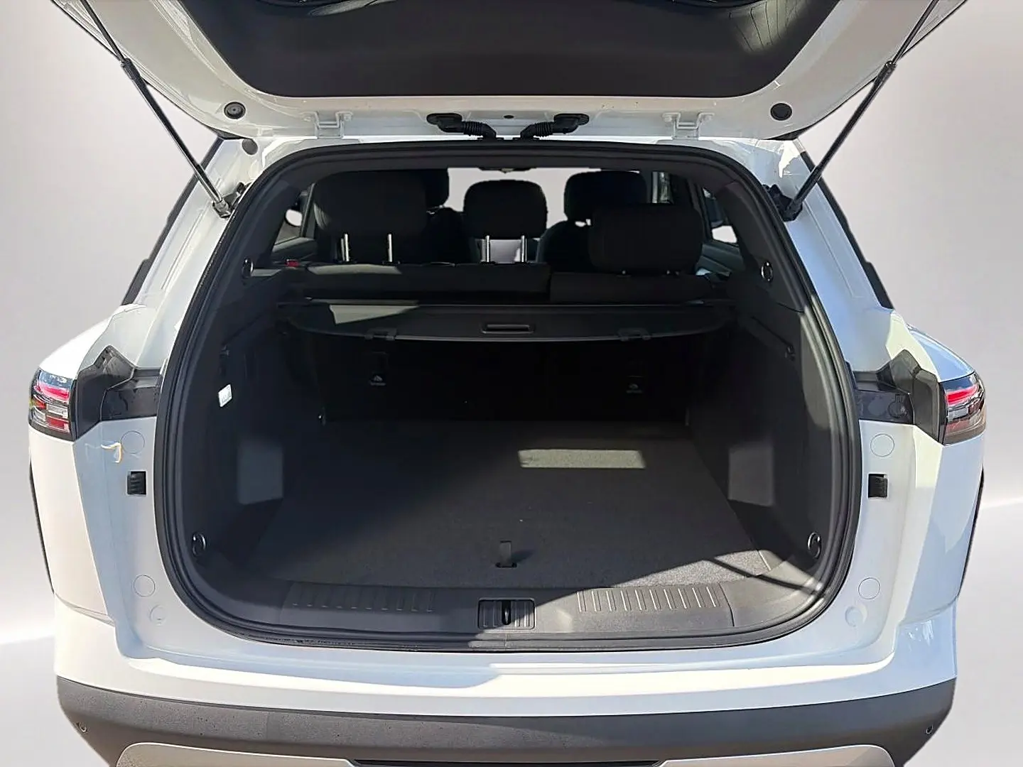 Vue arrière du coffre ouvert du JAECOO J7 blanc kaki, montrant l'espace de chargement et la banquette arrière noire.