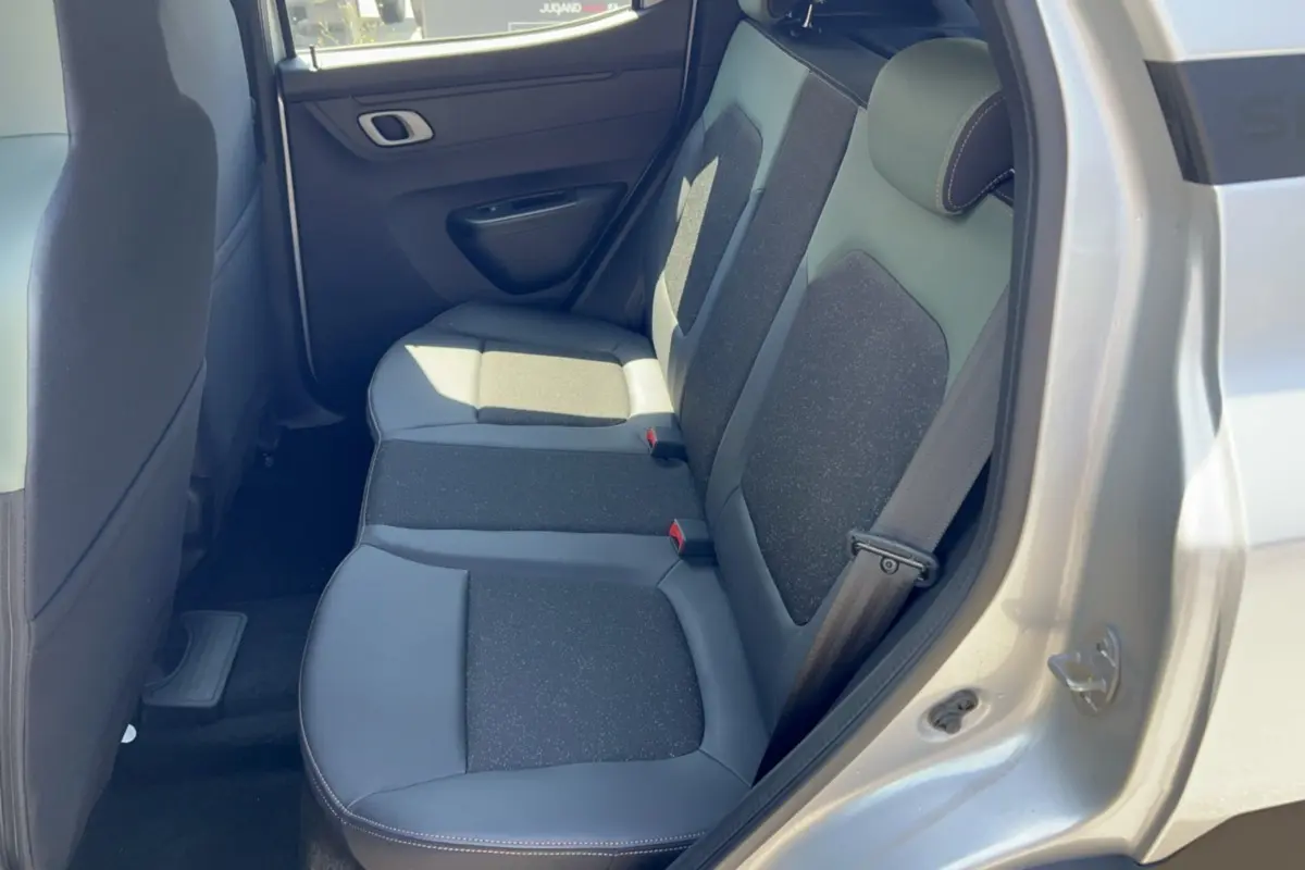 Vue intérieure des sièges arrière côté droit du Dacia Spring électrique gris éclair, sellerie cuir tissu bicolore.