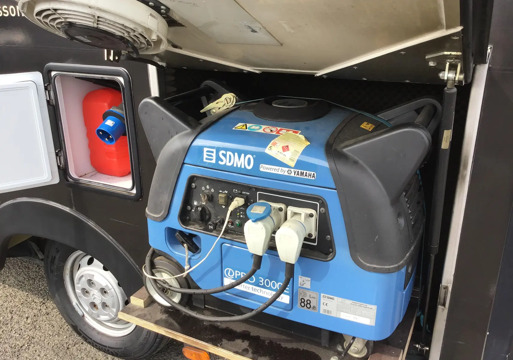 Gros plan sur groupe électrogène Yamaha bleu intégré côté gauche du Citroën Jumper gris Graphito 2017 food truck.