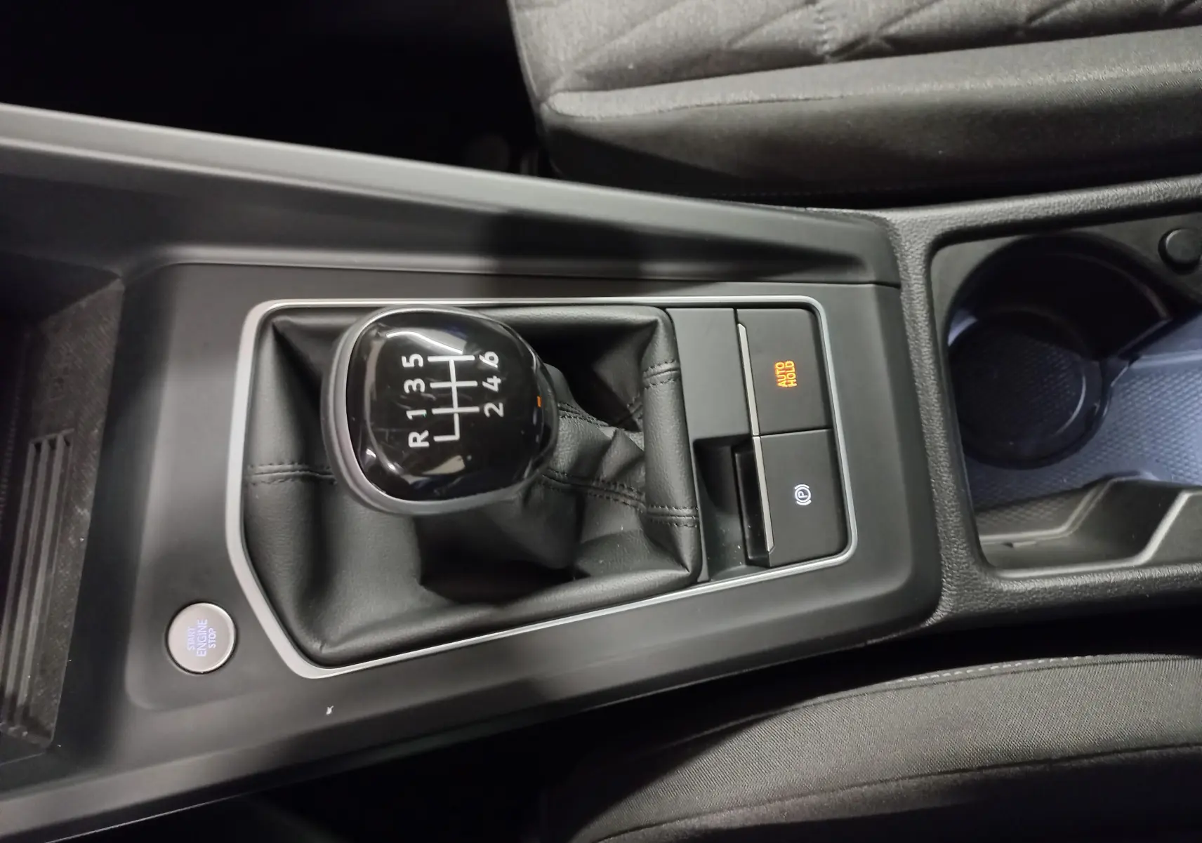 Vue rapprochée du levier de vitesses manuel de la Volkswagen Golf 1.5 TSI 116 BVM6 VW Edition avec bouton start/stop et frein à main électronique.