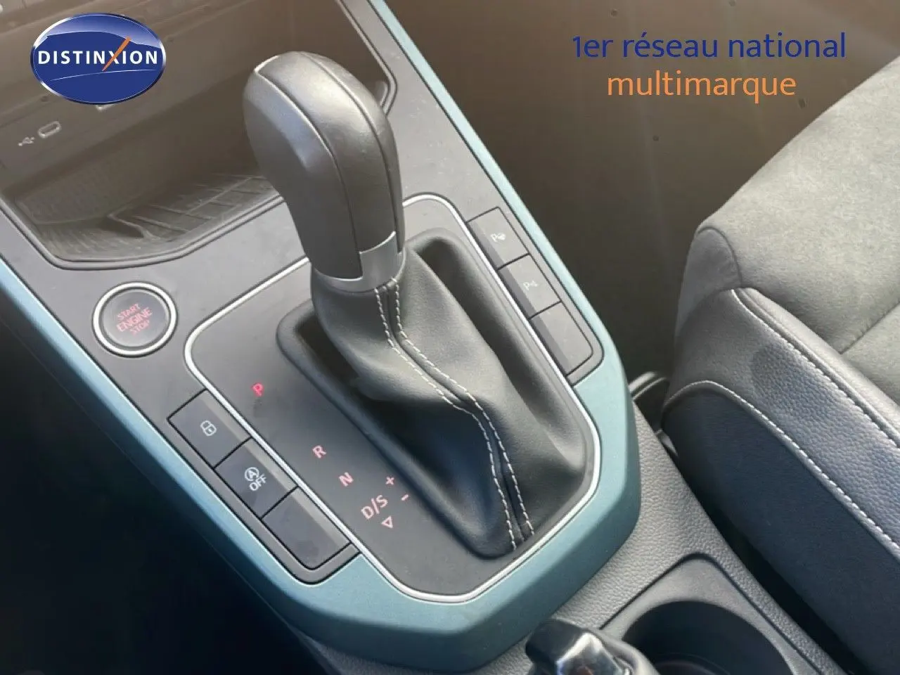 Gros plan sur la console centrale du SEAT Arona 2025, levier de vitesse automatique en cuir noir avec surpiqûres blanches.