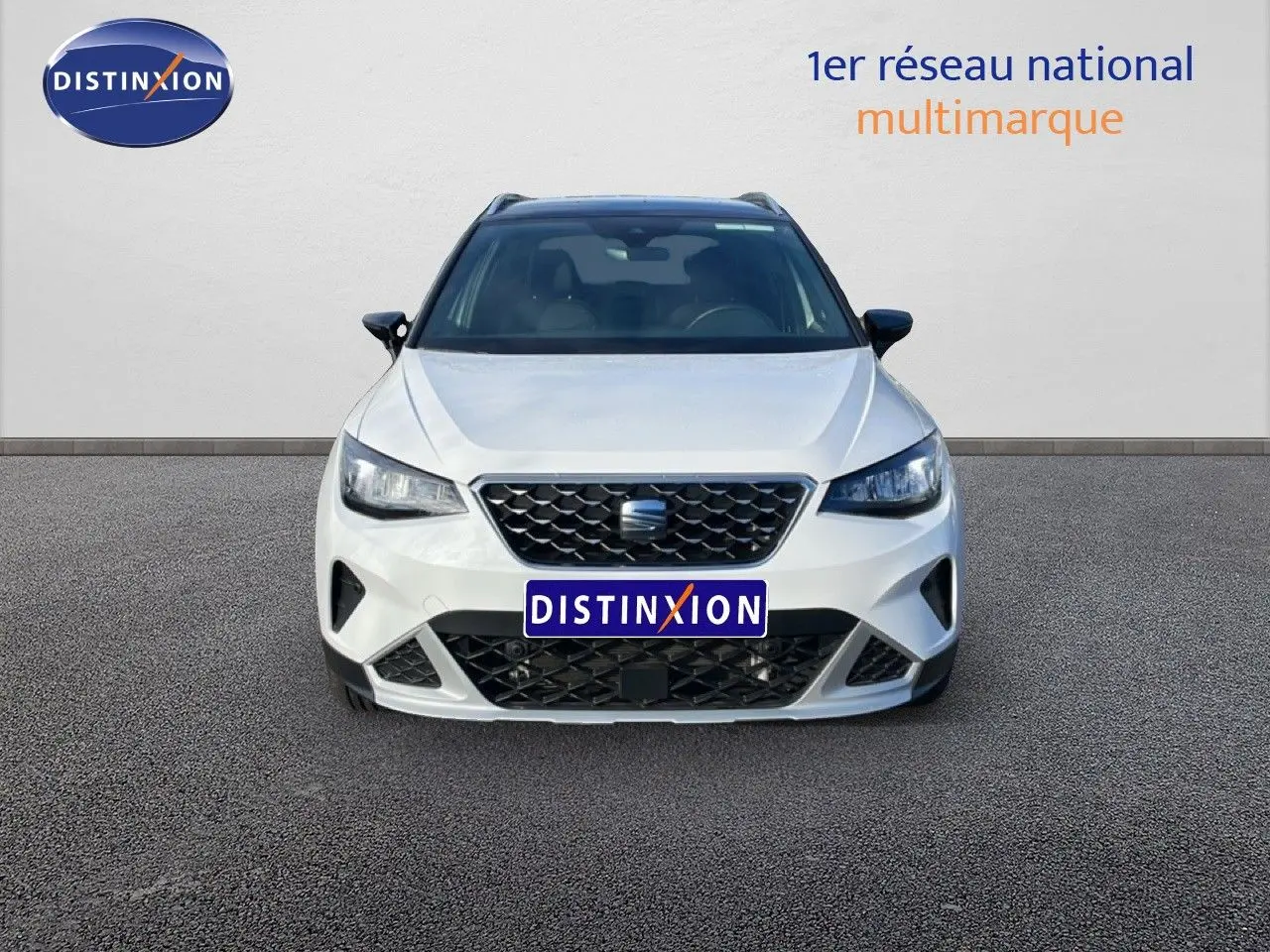 Vue frontale d'un SEAT Arona blanc avec toit noir, mettant en valeur sa calandre et ses phares LED.