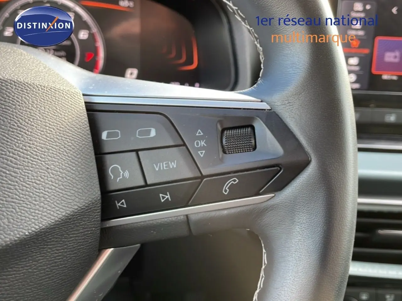 Gros plan sur le volant multifonction noir du SEAT Arona 2025, avec commandes audio et téléphone visibles.