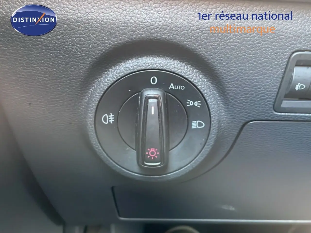 Gros plan sur la molette de commande des phares dans l’habitacle du SEAT Arona blanc toit noir, version 2025.