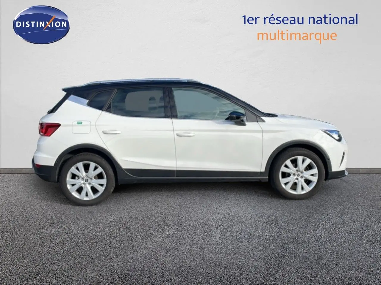 SEAT Arona blanc avec toit noir, vue profil droit, mettant en valeur ses jantes alliage et lignes dynamiques.