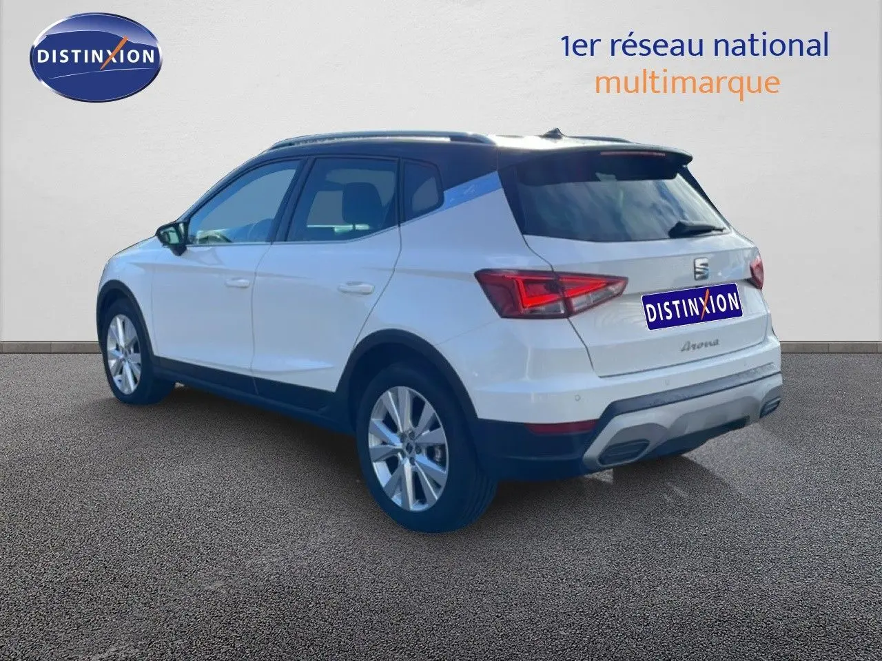 Vue 3/4 arrière droite du SEAT Arona blanc avec toit noir, jantes alliage et détails de carrosserie noirs.