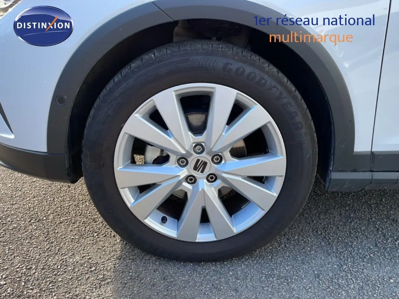 Gros plan sur la roue avant droite du SEAT Arona blanc avec jante alliage 17 pouces et logo central.