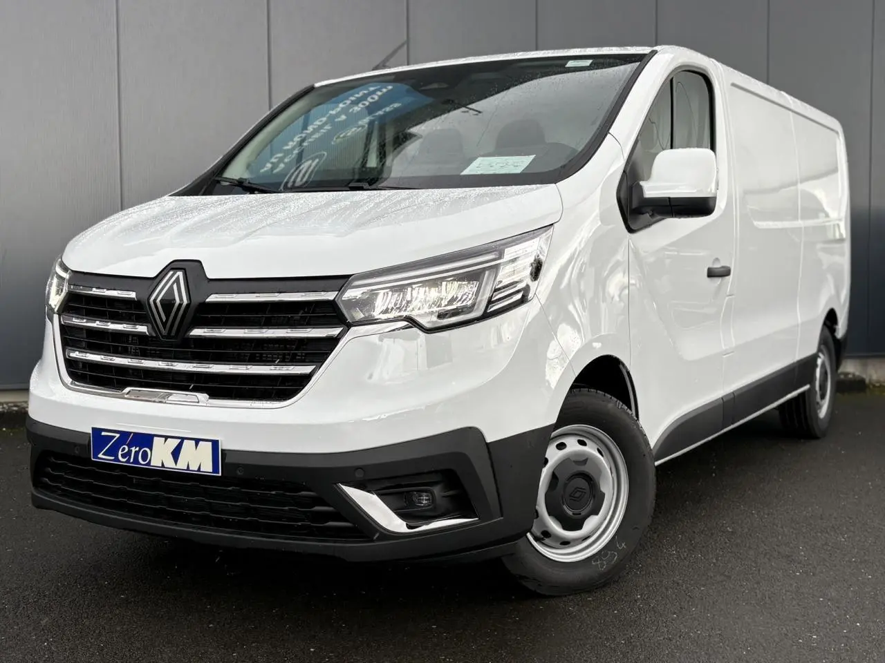 Vue 3/4 avant droit du Renault Trafic Fourgon blanc Glacier, avec calandre noire et jantes acier simples.