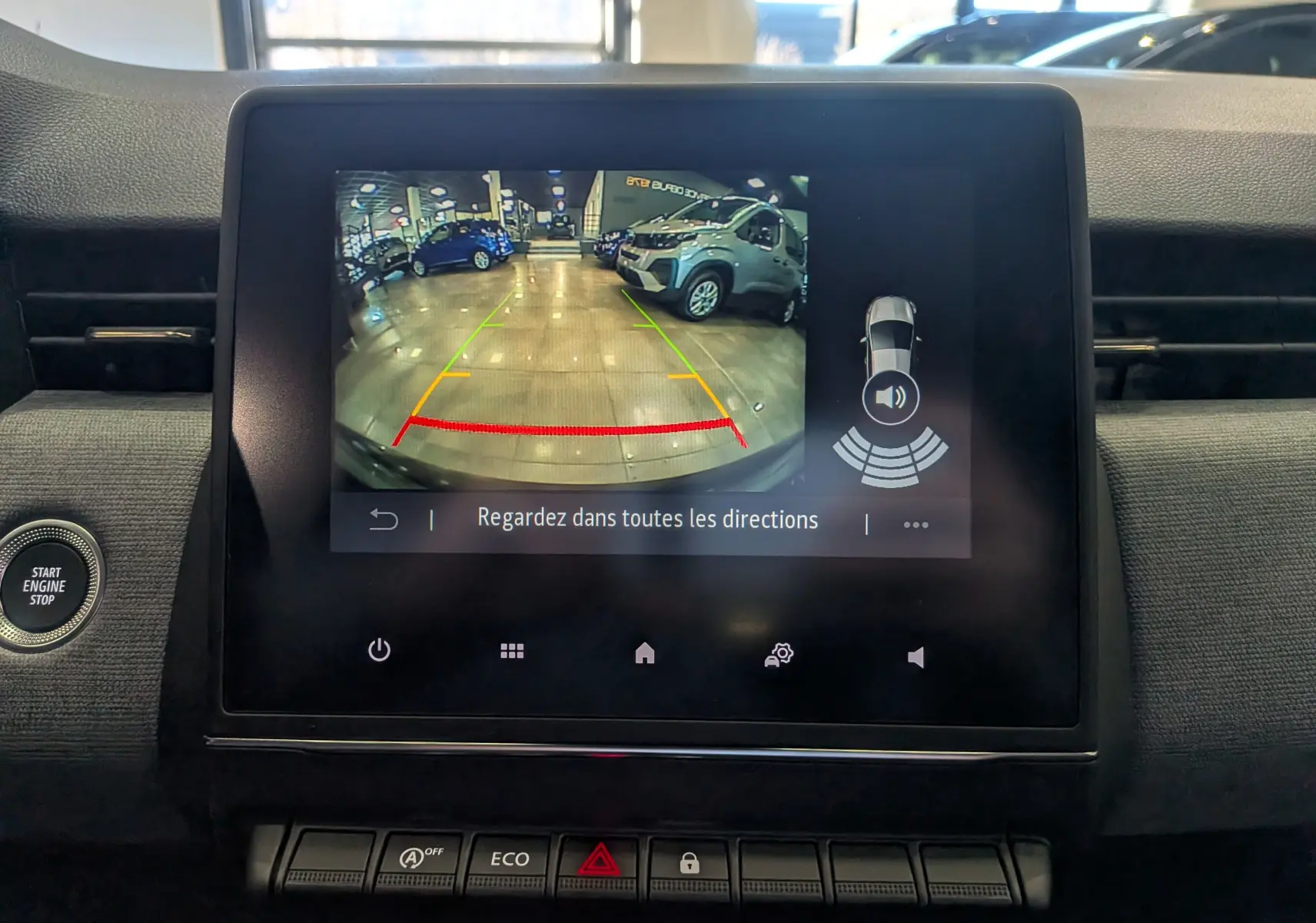 Vue de l'écran central montrant la caméra de recul avec guidage coloré dans une Renault Clio V noire, version Evolution.