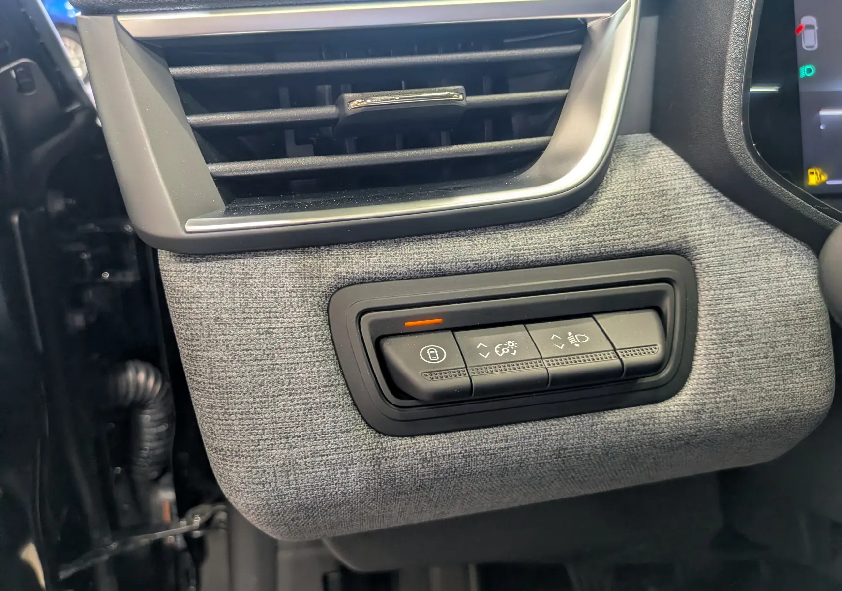 Détail intérieur côté gauche de la planche de bord grise avec commandes d’éclairage et ventilation de la Renault Clio V noire.