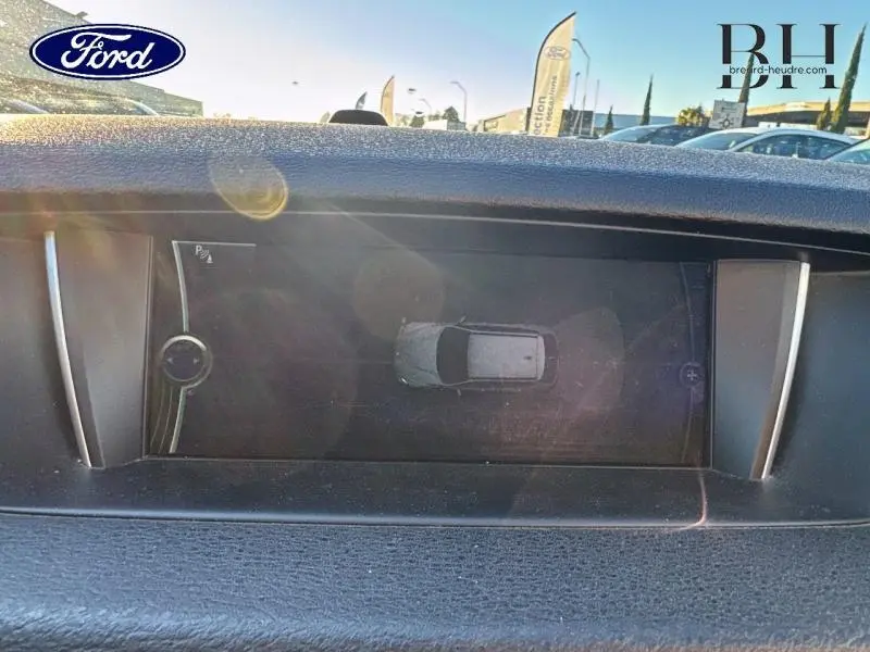 Écran de contrôle de stationnement d’un BMW X1 Mineralgrau, vue intérieure du tableau de bord en lumière naturelle.