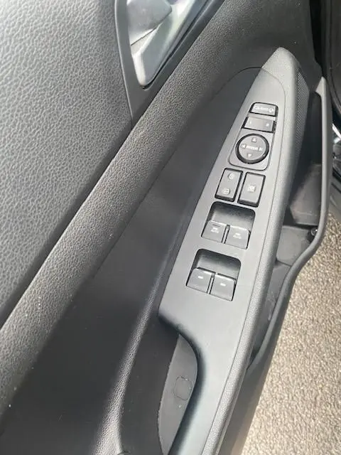 Vue rapprochée de la commande des vitres et rétroviseurs côté gauche intérieur d’un Hyundai Tucson noir de 2019.