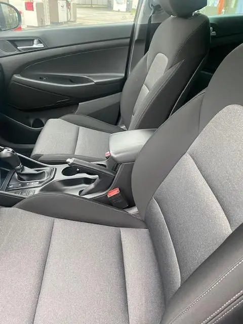 Vue intérieure côté droit du Hyundai Tucson 2019, sièges tissu gris et console centrale avec boîte automatique.