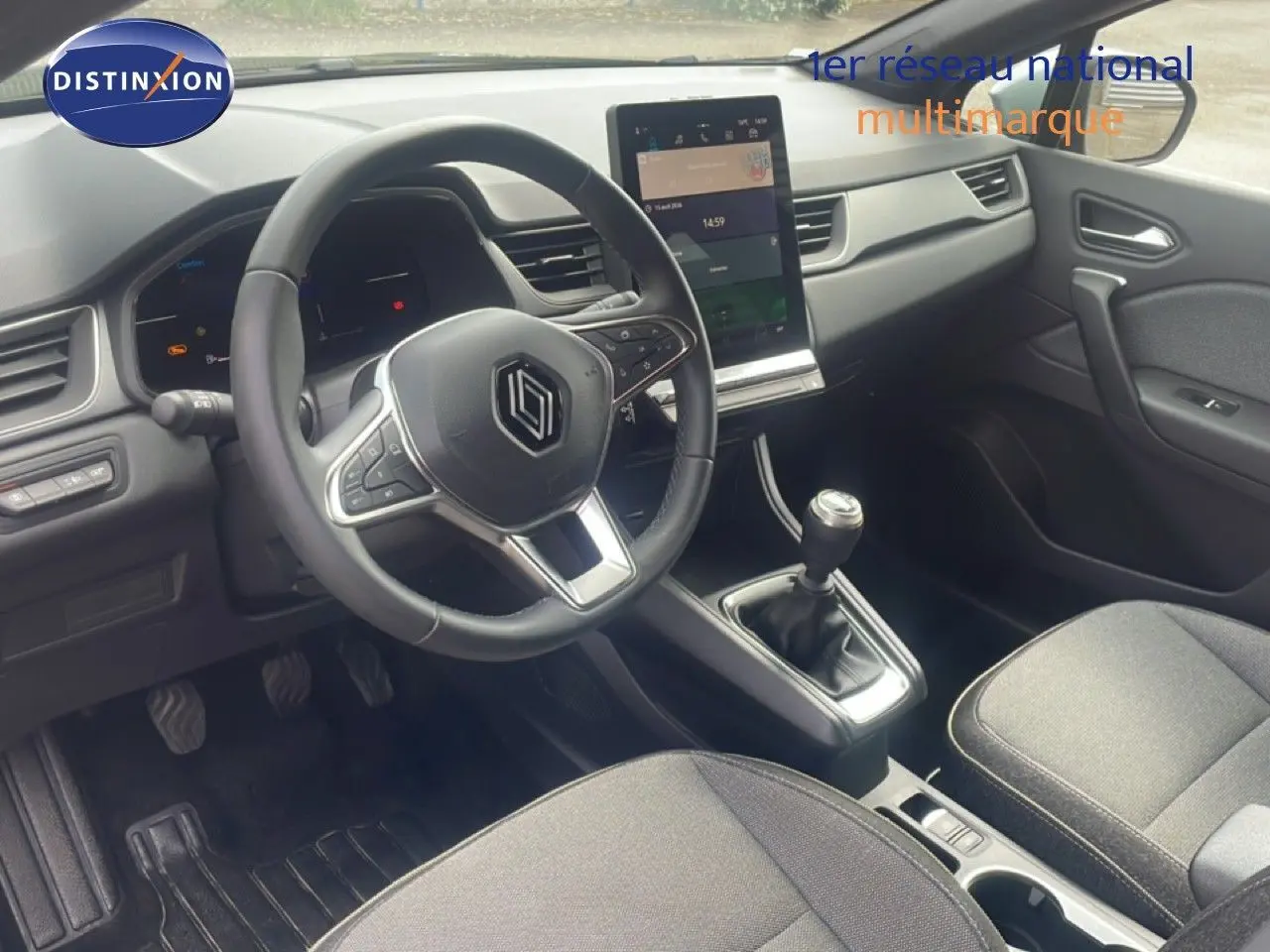 Vue intérieure avant du Renault Captur 2025, tableau de bord noir avec écran tactile vertical et volant multifonction.