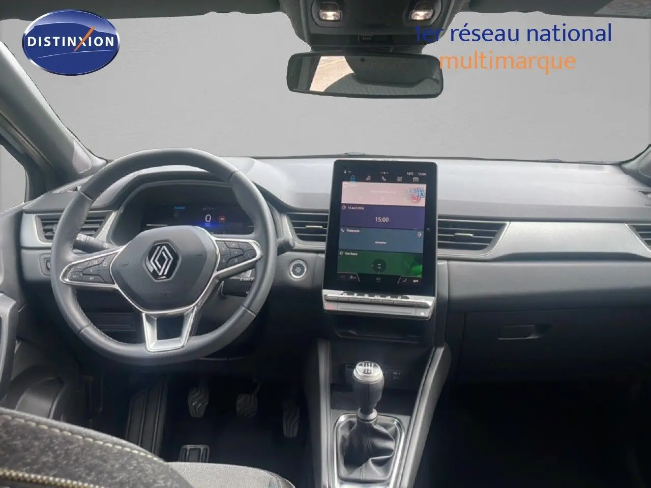 Vue intérieure avant du Renault Captur 2025, tableau de bord noir avec écran tactile vertical et volant multifonction.