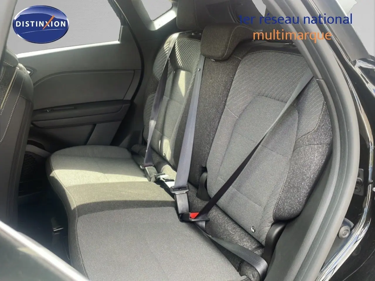 Vue intérieure côté droit des sièges arrière en tissu gris du Renault Captur noir étoile métal 2025 avec ceinture attachée.