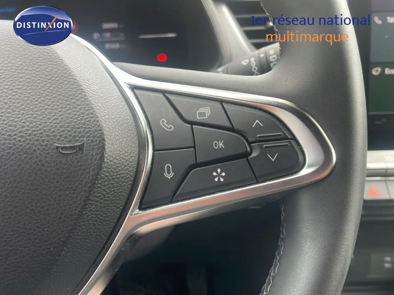 Gros plan sur les commandes multifonctions à droite du volant cuir noir du Renault Captur 2025, intérieur gris et noir.