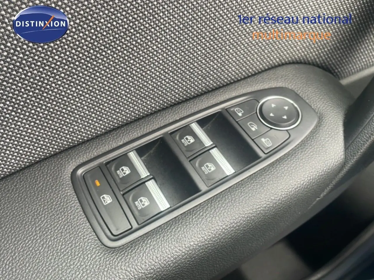 Gros plan sur la commande des vitres électriques côté conducteur du Renault Captur 2025, finition tissu gris noir.