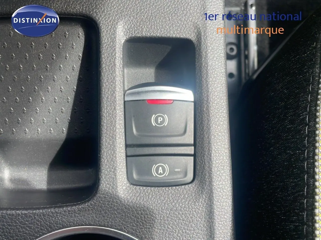 Gros plan sur la console centrale du Renault Captur 2025, montrant les boutons du frein à main électrique et du système start-stop.