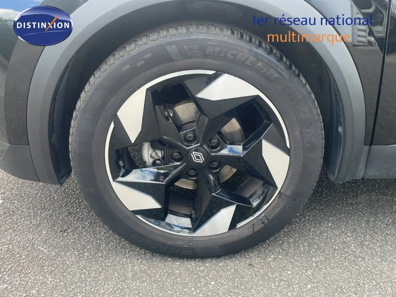 Gros plan sur la roue avant gauche du Renault Captur noir étoile métal avec jante biton au design géométrique.