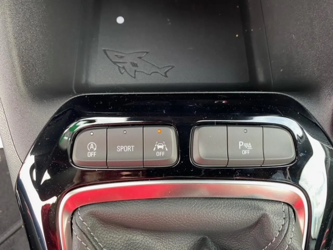 Gros plan sur les boutons de commande du mode Sport et aides à la conduite dans une Opel Corsa gris magnetic 2022.