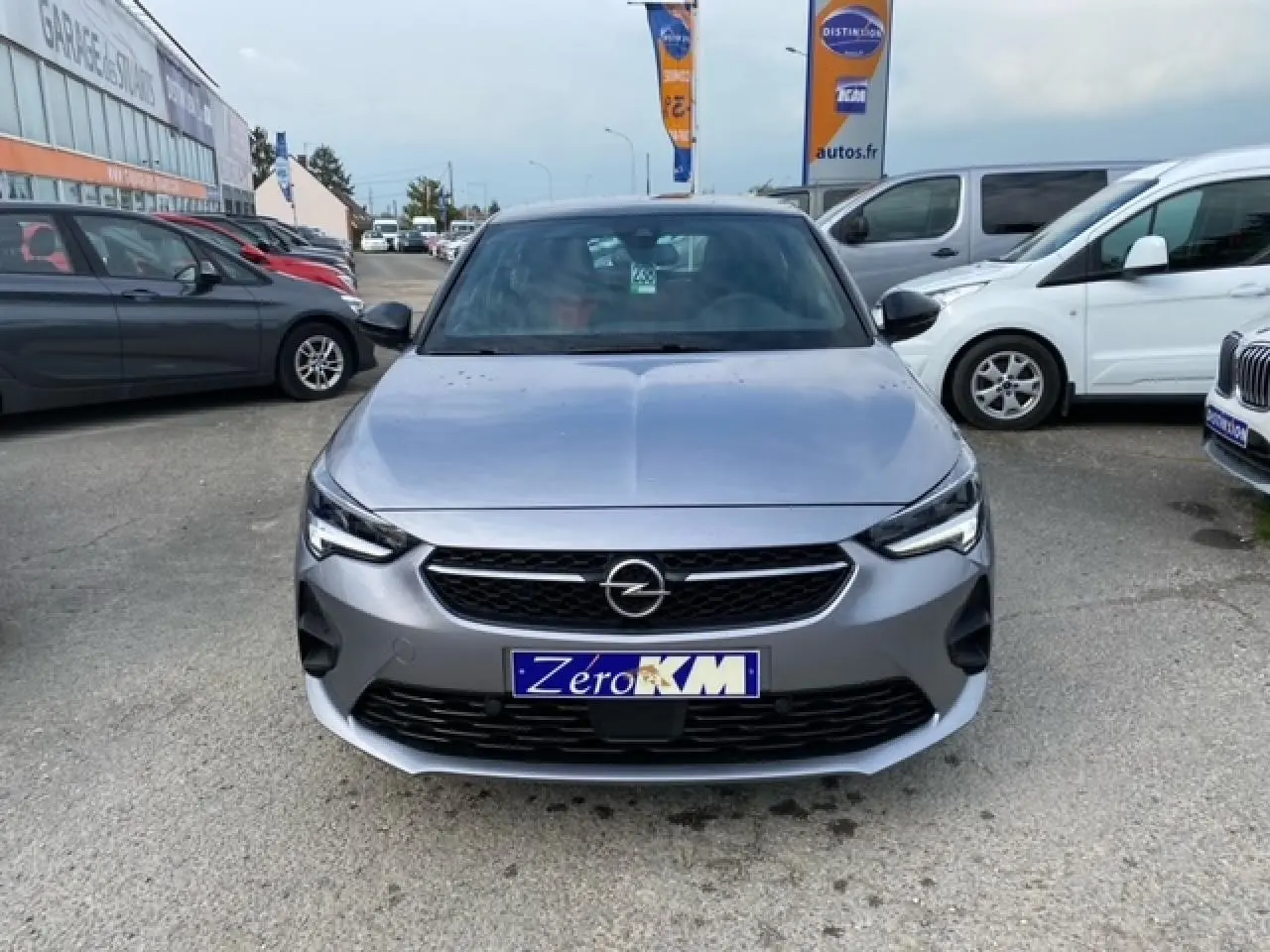 Vue avant d'une Opel Corsa 2022 gris magnetic avec calandre noire et phares LED allumés, stationnée en extérieur.