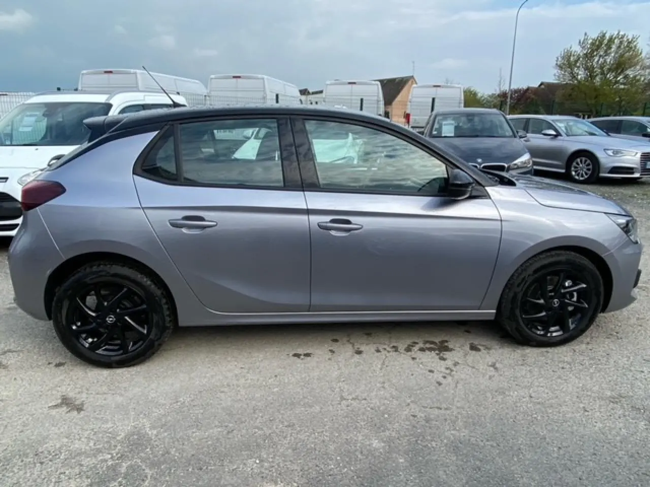 Vue latérale droite d'une Opel Corsa 2022 gris magnetic avec toit noir et jantes alliage noires brillantes.