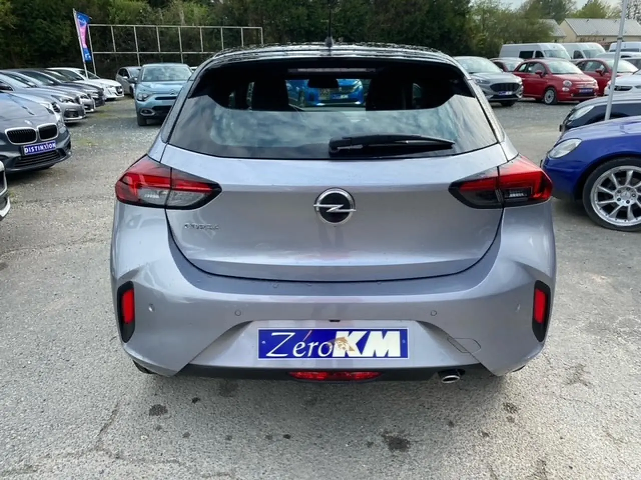 Vue arrière d’une Opel Corsa gris magnetic 2022 avec toit noir et feux arrière LED dans un parking.