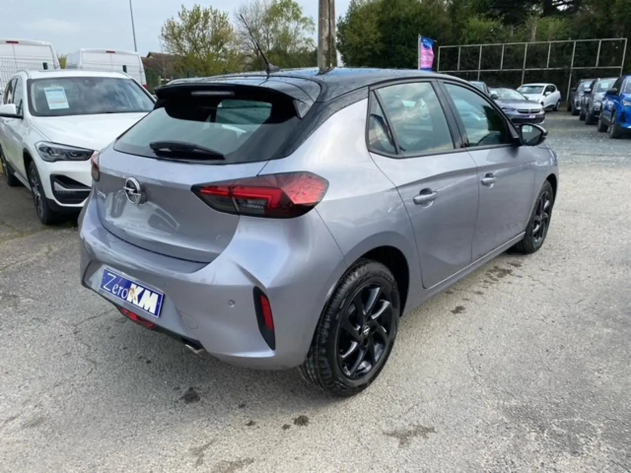 Opel Corsa 2022 gris magnetic en 3/4 arrière droit, toit noir et jantes alliage noires brillantes.