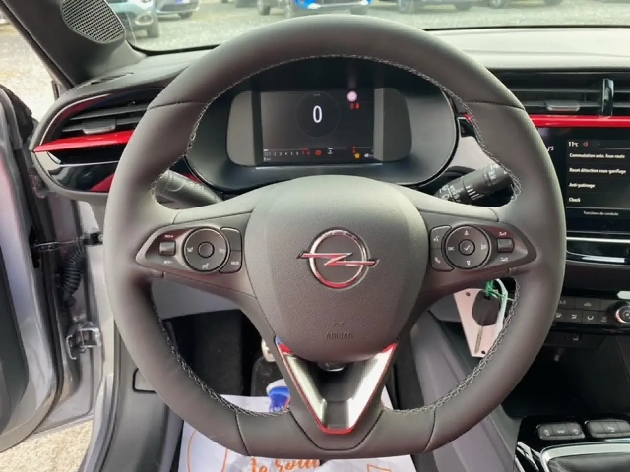 Vue intérieure centrée sur le volant cuir de l’Opel Corsa gris magnetic avec tableau de bord digital et touches multifonctions.