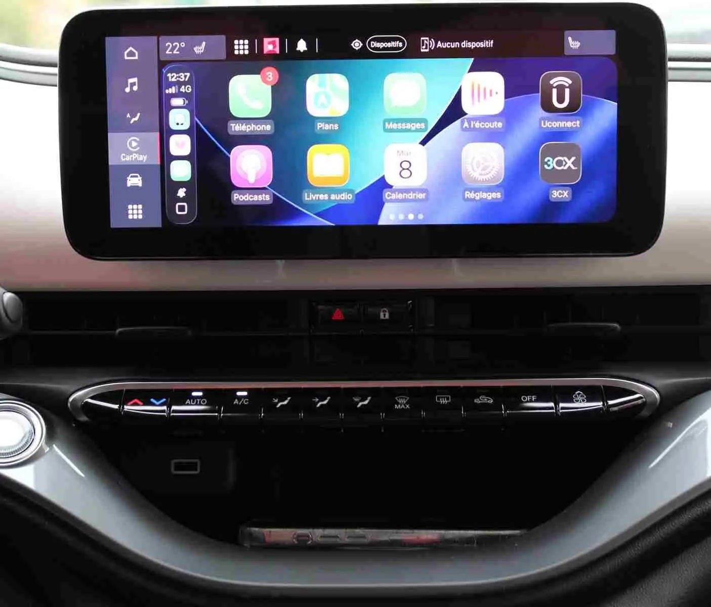 Écran tactile central affichant l'interface CarPlay sur le tableau de bord de la Fiat 500 électrique blanche.