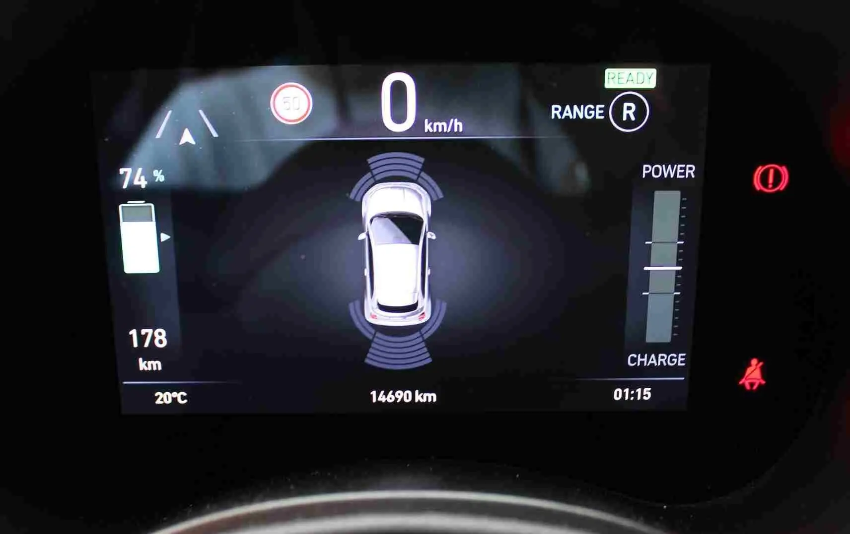 Affichage numérique du tableau de bord montrant la Fiat 500 électrique blanche vue de dessus avec autonomie et indicateurs de charge.