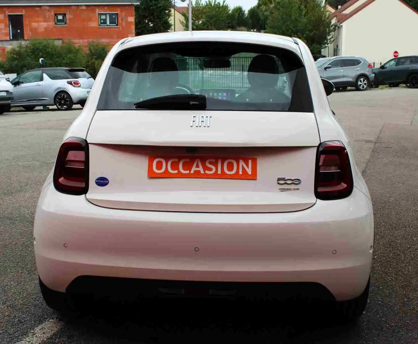 Vue arrière d'une Fiat 500 électrique blanche 2023 avec plaque "OCCASION" et feux arrière foncés.