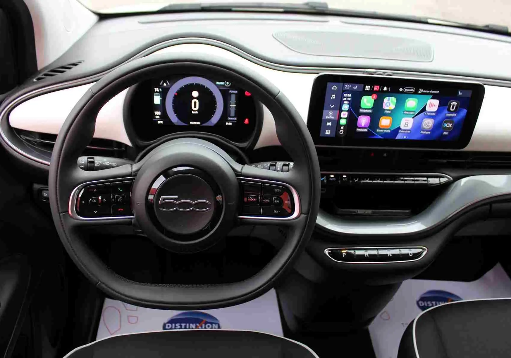 Vue intérieure centrée sur le tableau de bord et volant noir de la Fiat 500 électrique 2023 avec écran tactile couleur.