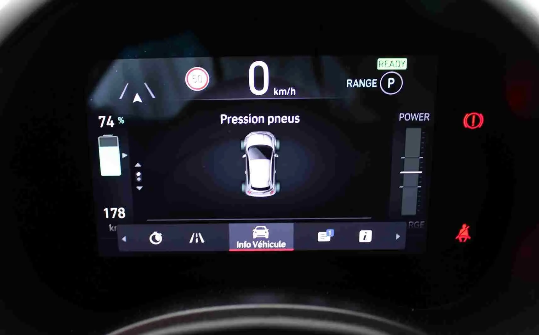 Affichage numérique du tableau de bord de la Fiat 500 électrique 2023 montrant la pression des pneus et l'autonomie à 74%.