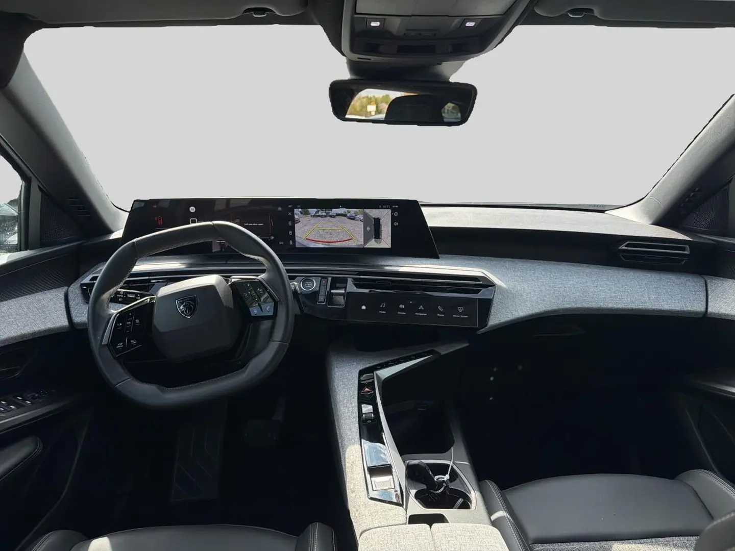 Vue intérieure avant du Peugeot 5008 blanc 2025, mettant en valeur le tableau de bord numérique et le volant cuir multifonction.