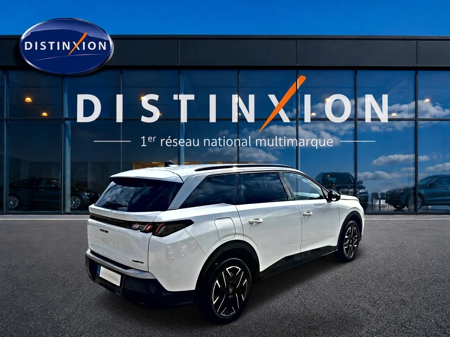 Peugeot 5008 Hybrid blanc vue 3/4 arrière droit, jantes alu noires et vitres arrière surteintées.