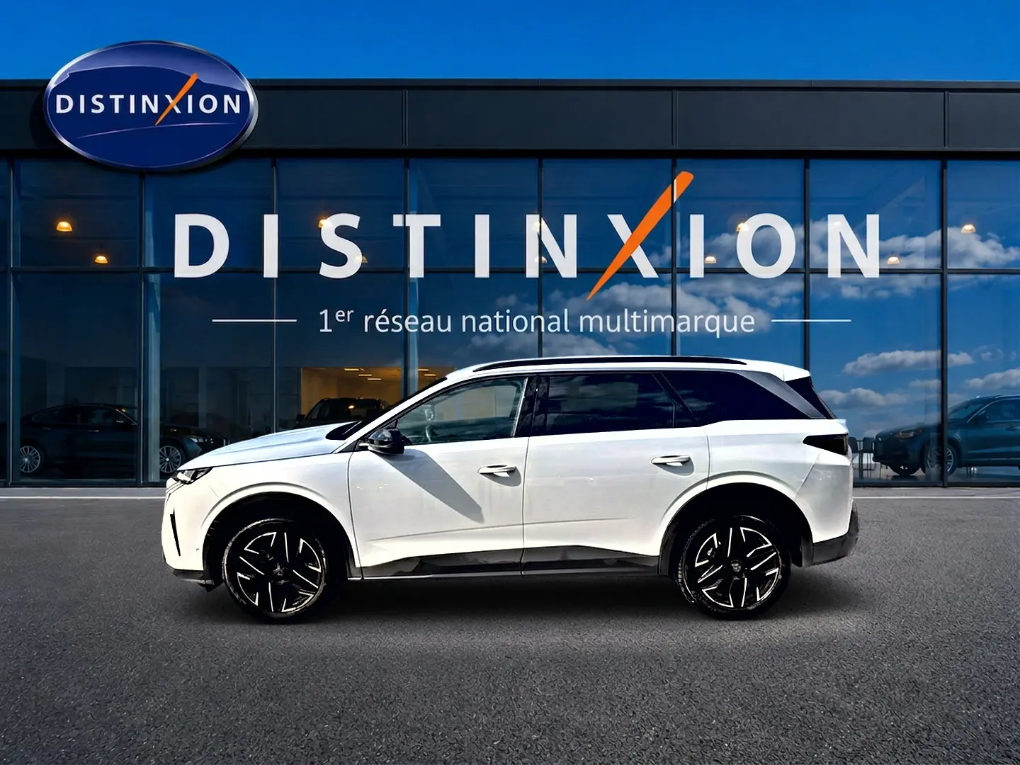 Peugeot 5008 Hybrid 145 allure e-dcs6 blanc vue de profil côté gauche devant une vitrine Distinxion.