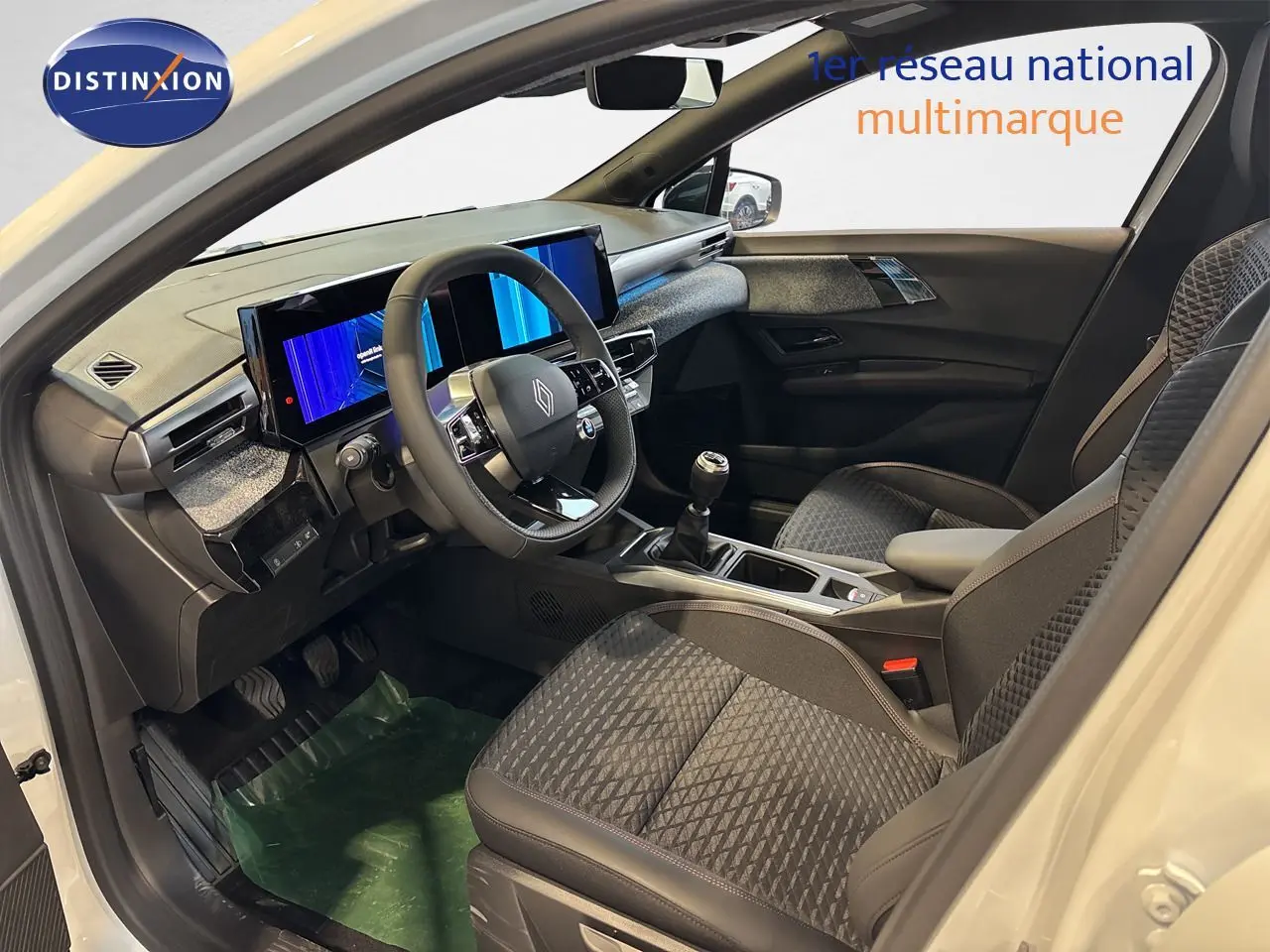 Vue intérieure côté conducteur de la Renault Clio VI TCe 115ch Techno blanche, volant cuir et écran digital double.