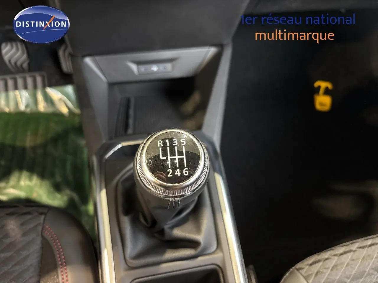 Gros plan sur le levier de vitesses manuel de la Renault Clio VI TCe 115ch Techno, intérieur noir avec surpiqûres rouges.