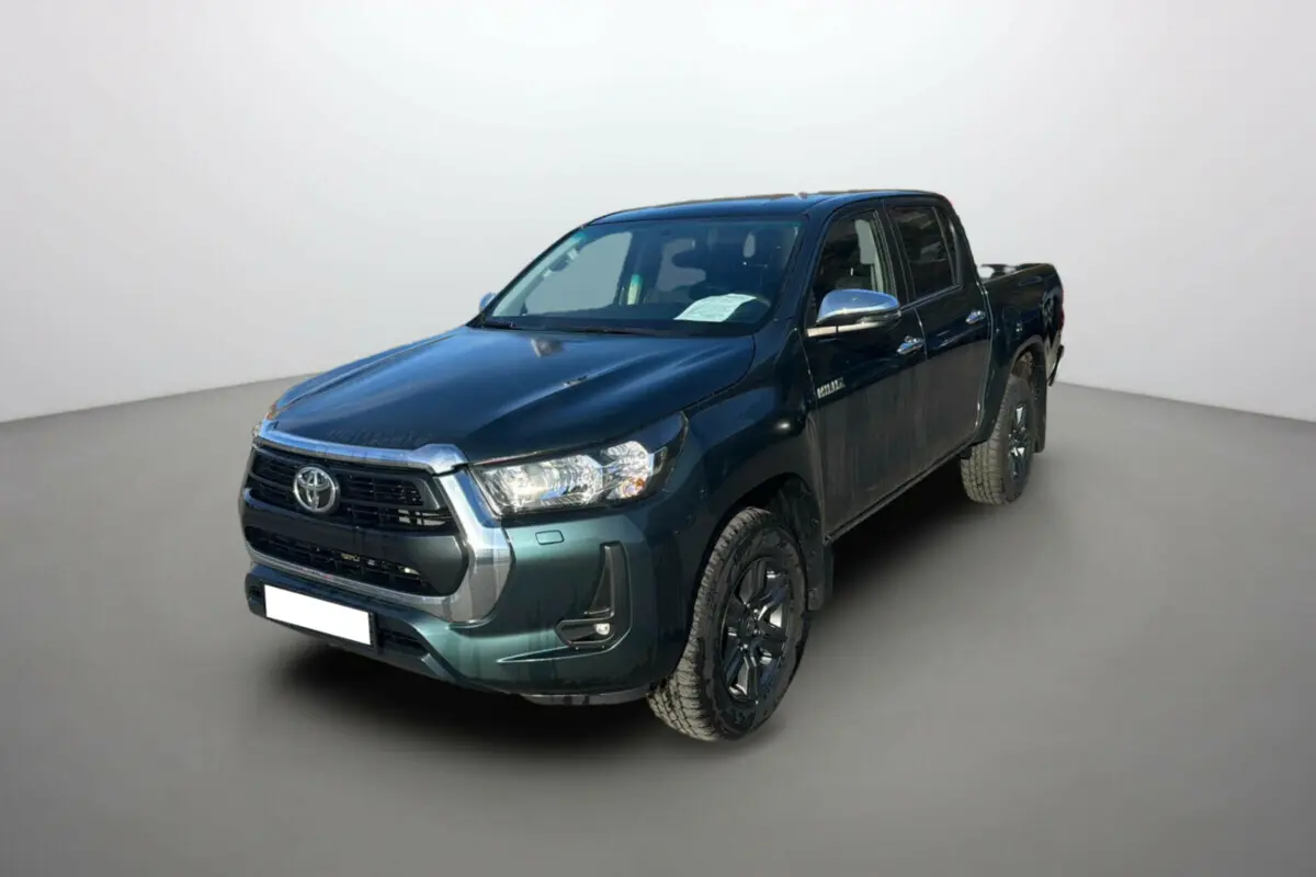 Toyota Hilux 2025 vert métal en 3/4 avant droit, pick-up 4x4 robuste avec jantes noires et calandre chromée.