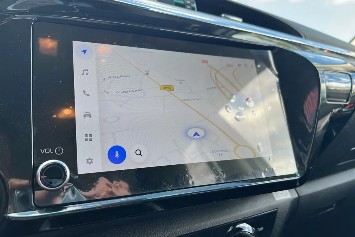 Écran tactile du système de navigation du Toyota Hilux 2025, affichant une carte routière avec commandes tactiles.