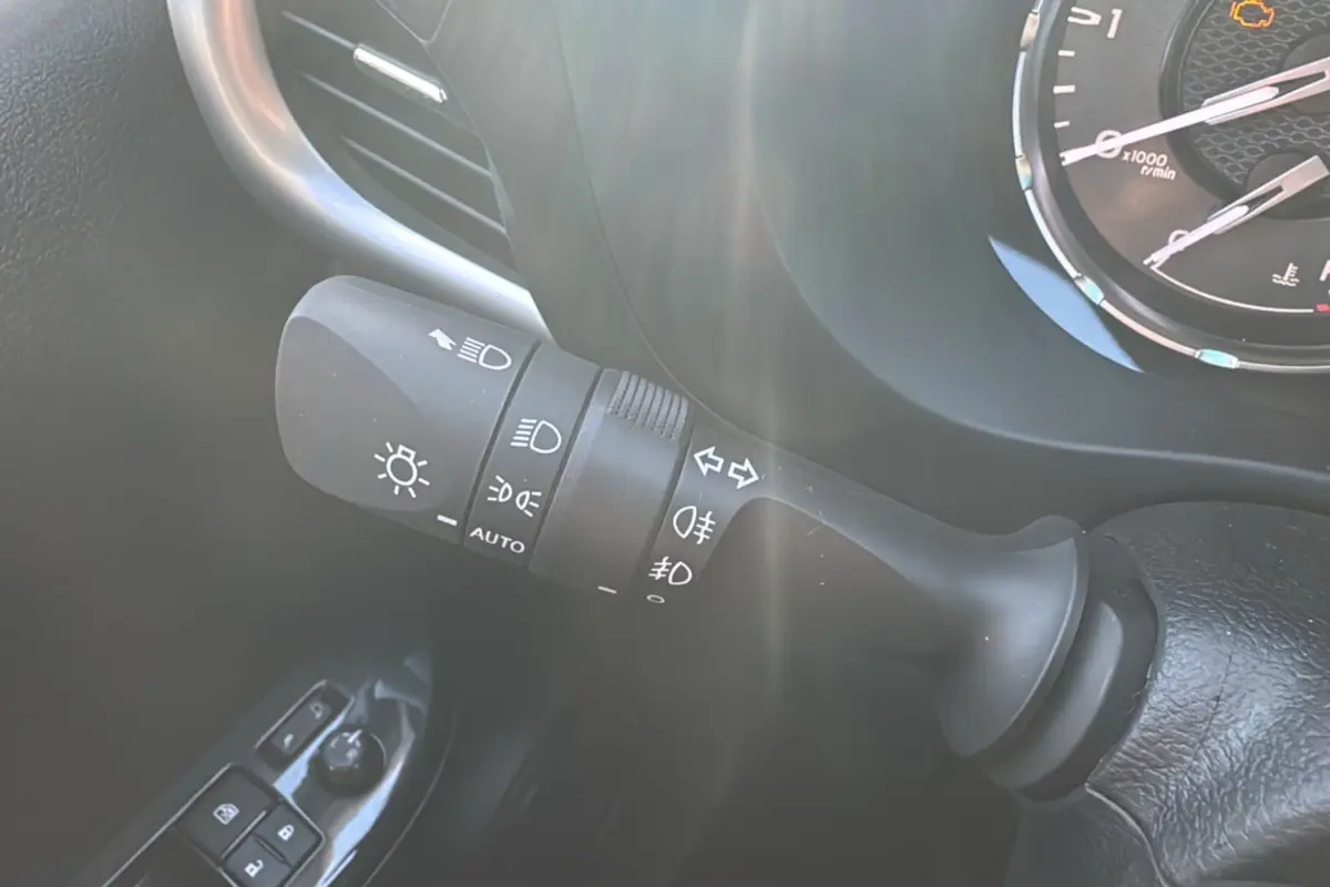 Gros plan sur la commande des phares et clignotants du Toyota Hilux 2025, finition Légende, intérieur noir.